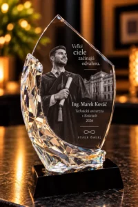 Crystal award trophy featuring a graduate in cap and gown, with Slovak inscription and a university building image; awarded in 2026 to Ing. Marek Kovác (Košice).
