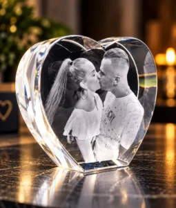 Heart-shaped crystal keepsake with a couple kissing inside on a reflective surface (black-and-white photo)