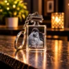 prívesok obdĺžnik | Gravírovanie fotiek do skla - darček s venovaním Crystal keychain with a photo of a couple embracing and the caption 'Si môj život.' on a marble surface, warm bokeh lights in the background.